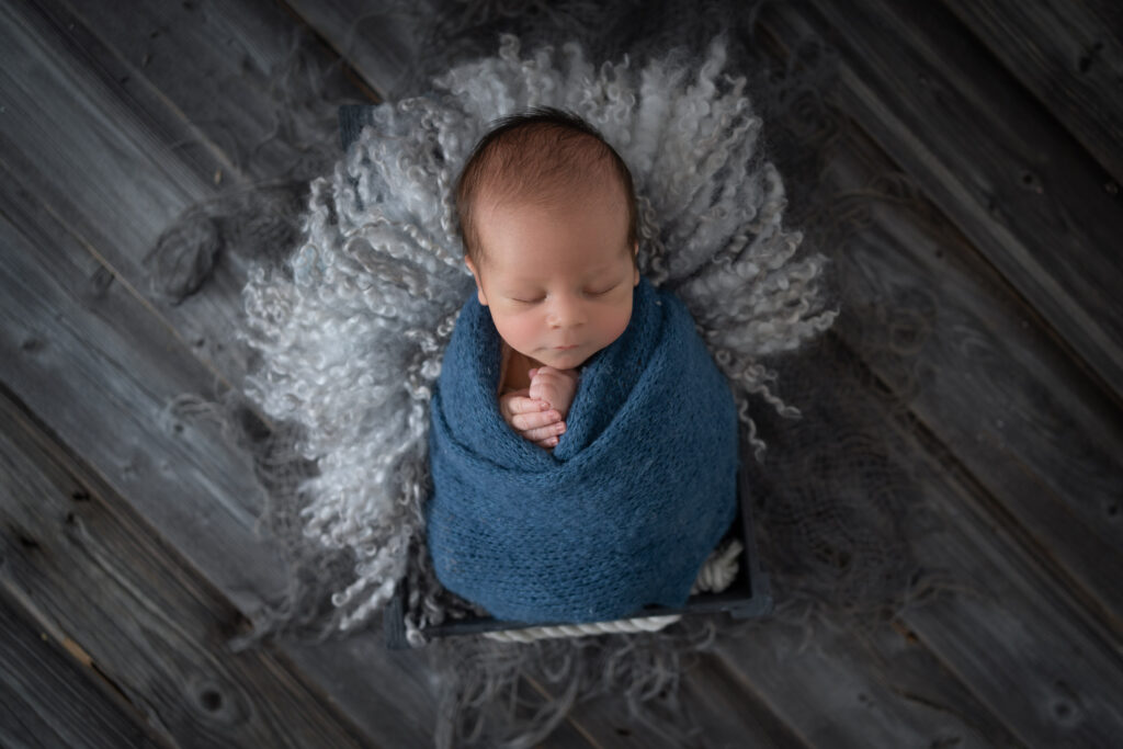 Neugeborenes Baby in blauer Decke - Foto von Nathalie Weber